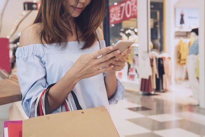 Woman holding umbrella standing at store