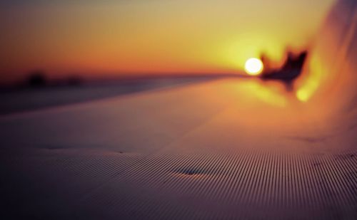 Close-up of hand on beach at sunset