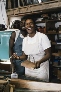 Happy male and female entrepreneurs in upcycling workshop