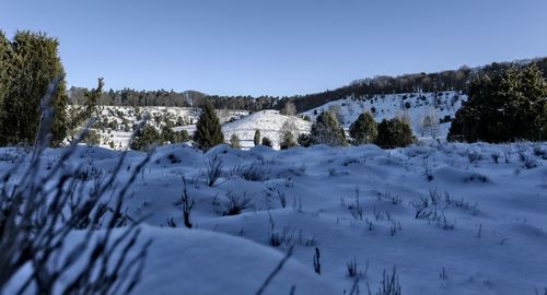 Scenic view of snow covered land against clear sky