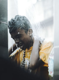 Portrait of young man looking through window