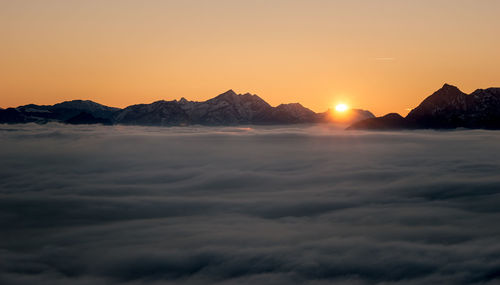 Scenic view of majestic mountains against sky during sunset