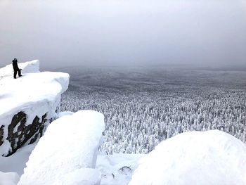 Snow covered landscape against sky during winter