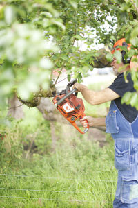 Senior man with chainsaw in garden