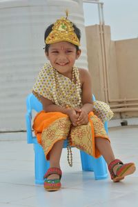 Portrait of a smiling girl sitting outdoors