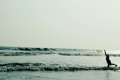 Man standing on beach against clear sky