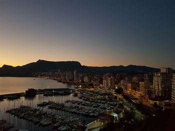 High angle view of city by sea against clear sky