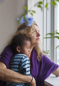 Mother with son looking through window