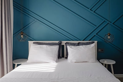 Stylish bedroom in contemporary style with blue colored wooden decorative wall. modern inteior