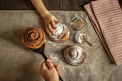 Midsection of person holding ice cream on table