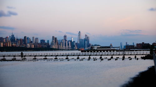 Panoramic view of river and buildings against sky during sunset