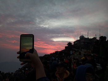 People photographing against sky at sunset