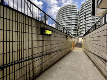 Footpath amidst buildings against sky in city