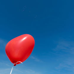 Low angle view of balloons against blue sky