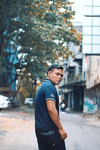 Portrait of young man standing on road