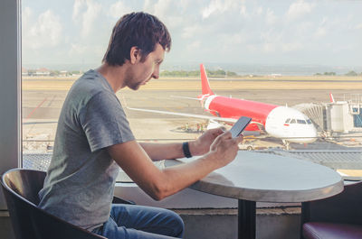 Side view of man sitting on table