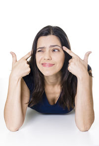 Mature woman gesturing while lying over white background
