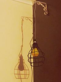 Low angle view of electric lamp against wall