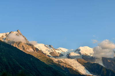 Scenic view of snowcapped mountains against clear blue sky