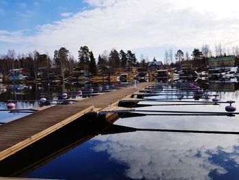 Boats in canal by city against sky