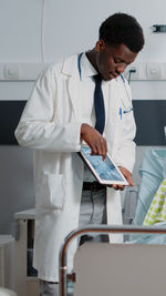 Doctor showing medical tablet in clinic