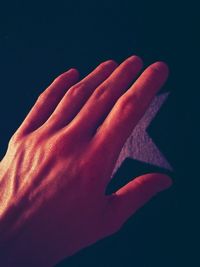 Close-up of woman hand against black background