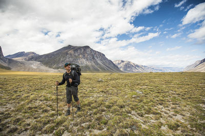 Backpacker hiking through open valley in the arctic.