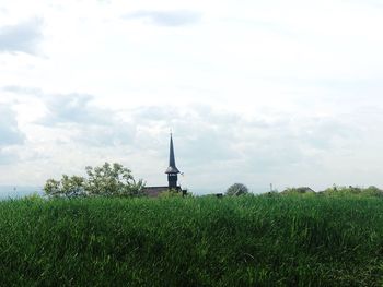 Traditional windmill on field against sky