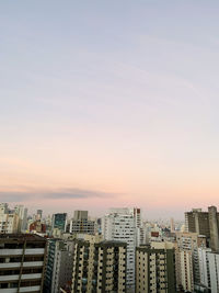 Buildings in city against sky during sunset