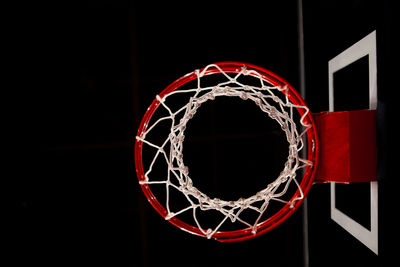 Directly below shot of basketball hoop against black background