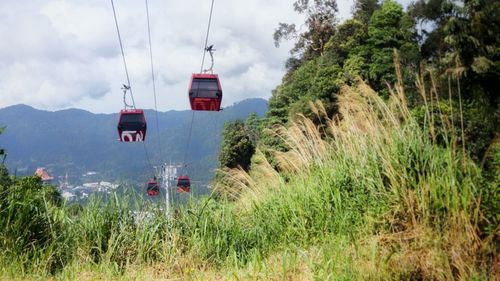 Overhead cable car over mountains against sky