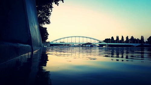 Bridge over river in city against clear sky