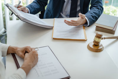 Low section of man sitting on table