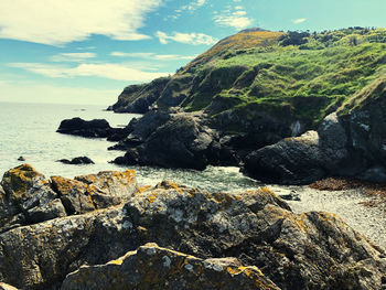 Rocks by sea against sky