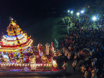 Group of people in illuminated traditional building at night