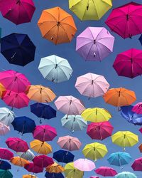 Low angle view of colorful umbrellas hanging against sky