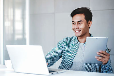 Portrait of smiling young man using mobile phone