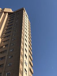 Low angle view of buildings against clear blue sky