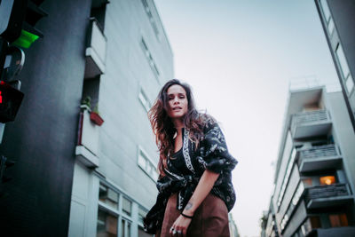 Low angle view of woman against buildings in city