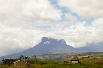 Scenic view of houses and mountains against sky