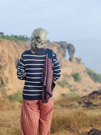 Rear view of woman standing on mountain