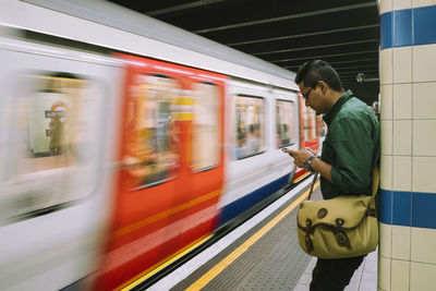 Blurred motion of man standing on train at railroad station