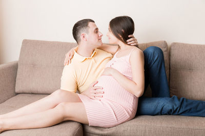 Young couple sitting on sofa at home