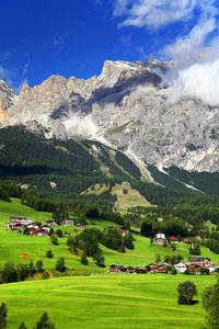 Houses on field against dolomites