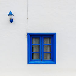 Closed blue wall with lamp on white wall