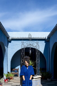 Woman posing in robe outdoors in a countryside house.