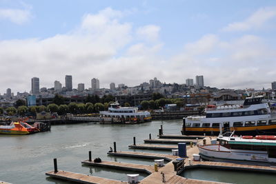 Boats moored in river against buildings in city