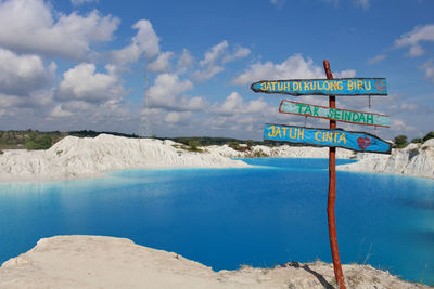 Information sign on land against sky
