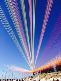 Low angle view of colorful cables against clear blue sky at beach
