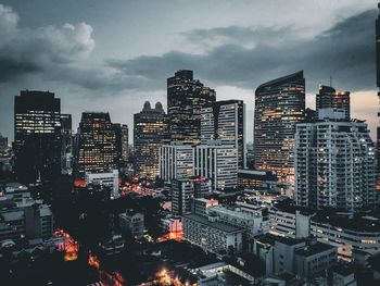 Illuminated buildings in city against sky